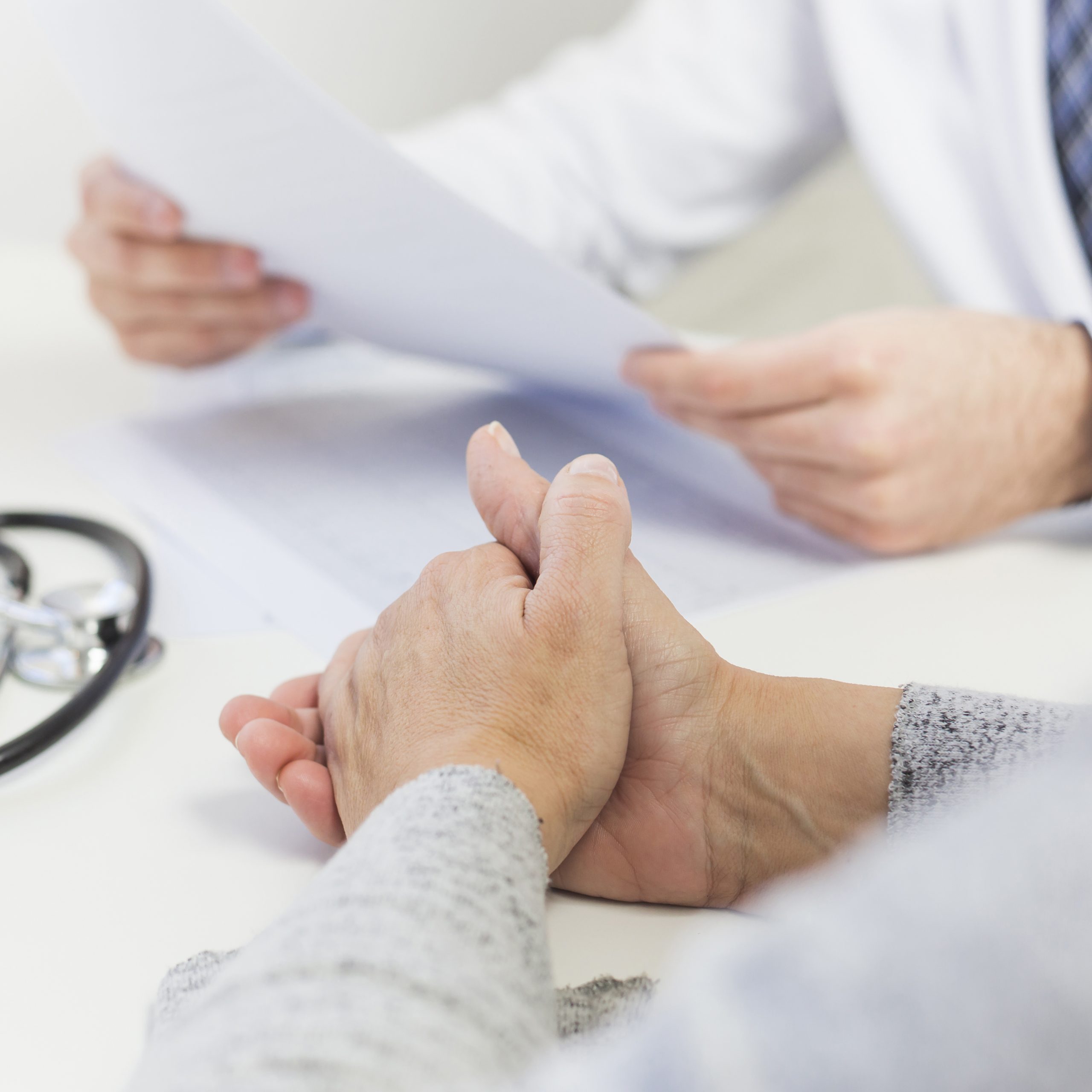 close up female patient sitting near doctor holding medical report close up female patient sitting near doctor holding medical report
